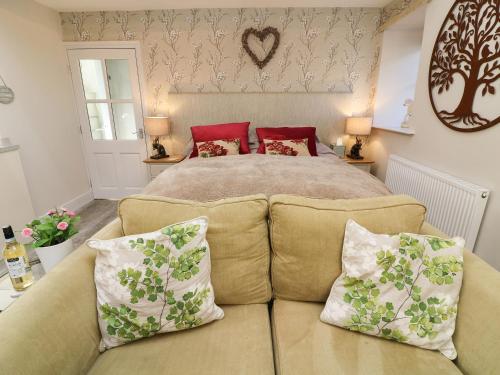 a bedroom with a bed and a couch with pillows at Lottie's Loft in Grassington