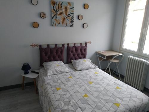 1 dormitorio con 1 cama con edredón blanco y amarillo en Le Risle - Hôtel, en Montfort-sur-Risle