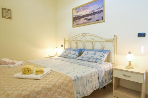 een slaapkamer met een bed met twee handdoeken erop bij New Apartment Leuca in Leuca