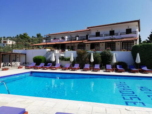 ein Hotel mit einem Pool vor einem Gebäude in der Unterkunft Hotel Paradise in Vassilias