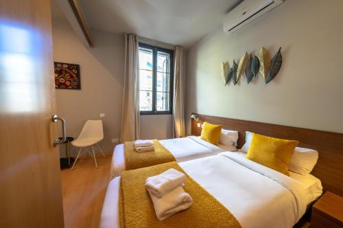een slaapkamer met 2 bedden en gele kussens bij Bonavista Apartments - Eixample in Barcelona
