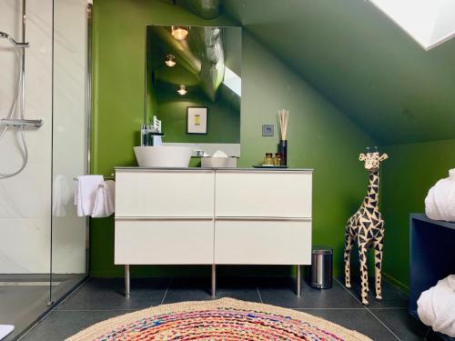 a bathroom with a white dresser and a giraffe statue at Hôtel - Restaurant Le Globe in Meursault
