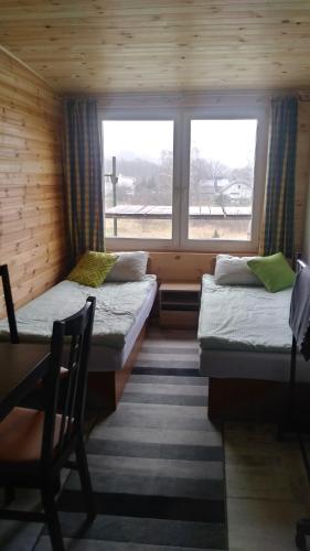 two beds in a room with a window at Max in Żukowo