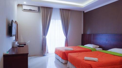 a hotel room with two beds and a window at Bumi Gumati Resort & Convention in Bogor