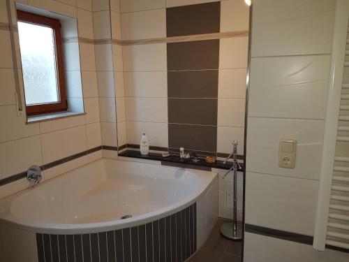 eine Badewanne im Bad mit Fenster in der Unterkunft Ferienwohnung Schortestraße in Ilmenau