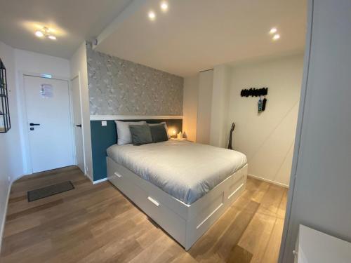 a bedroom with a white bed and a door at hill4 in Ostend