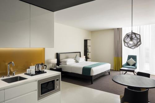 a hotel room with a bed and a kitchen at Staybridge Suites Al Khobar, an IHG Hotel in Al Khobar