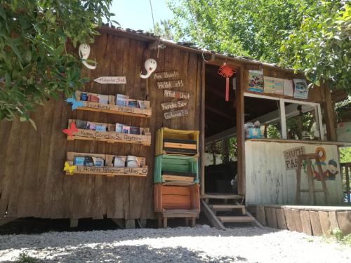 un magasin avec des chaises assises à l'extérieur d'un bâtiment dans l'établissement Olympos Yakamoz Pansiyon, à Olympos