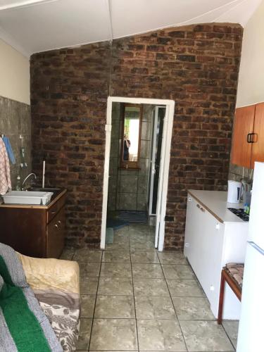 a kitchen with a brick wall and a doorway at Tranquility in Klein Karoo in Oudtshoorn