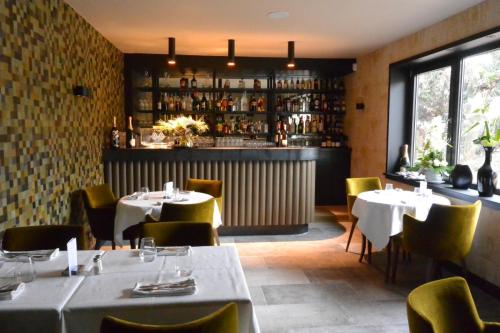 un restaurant avec des tables et des chaises et un bar dans l'établissement La Maison du Faisan Doré, à Villefranche-sur-Saône