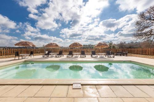 a swimming pool with chairs and tables and a fence at B&B Mariano in Ceglie Messapica