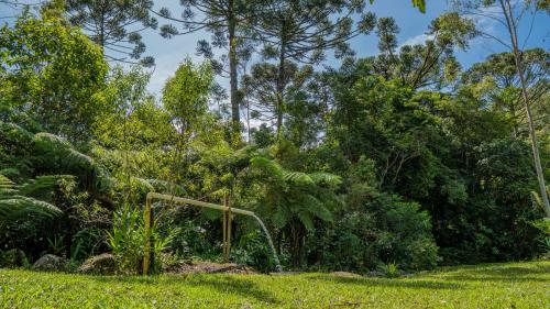 a playground in a field with trees in the background at Chalés Das Estrelas in Visconde De Maua