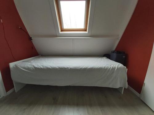 a bed in a small room with a window at Woodpecker - bungalow 29 in Durbuy