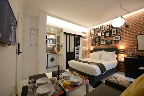 Résidence Voûte في باريس: غرفة نوم مع سرير وغرفة معيشة