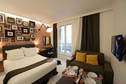 um quarto de hotel com uma cama e um sofá em Résidence Voûte em Paris