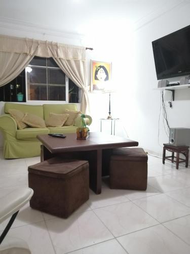 a living room with a green couch and a coffee table at Posada Dilia del Alba in Santo Domingo