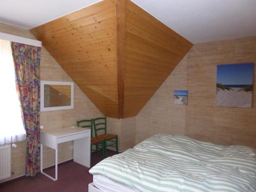 a bedroom with a bed with a wooden ceiling at Ferienwohnung Gartenblick in Eystrup