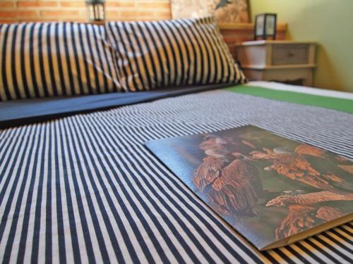 a bed with a comforter with a book on it at Observatorio de Buitres Mas de Bunyol in Valderrobres
