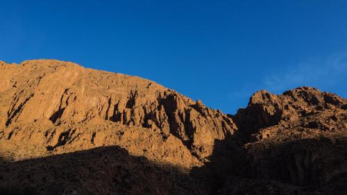 a brown mountain with a blue sky in the background at Riad Kasbah des Roches in Akhendachou nʼAït Ouffi