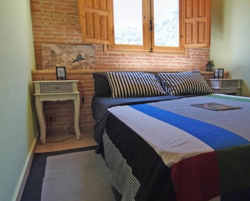 a bedroom with two beds and a table with a window at Observatorio de Buitres Mas de Bunyol in Valderrobres