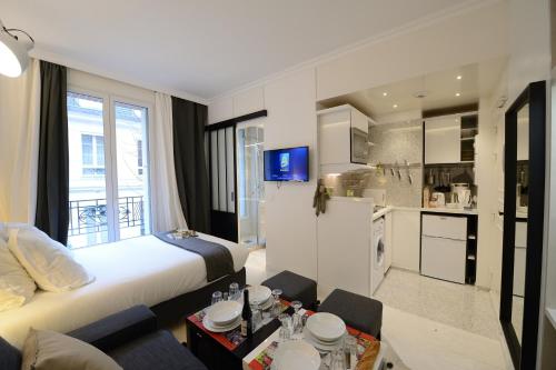 une chambre d'hôtel avec un lit et une cuisine dans l'établissement Résidence Voûte, à Paris