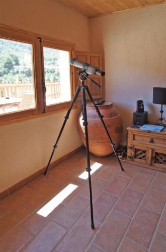 a camera on a tripod in a room with a window at Observatorio de Buitres Mas de Bunyol in Valderrobres