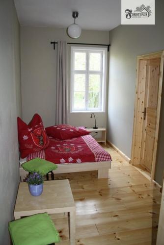 a bedroom with a red bed and a window at Forsthaus Leiner Berg in Dessau