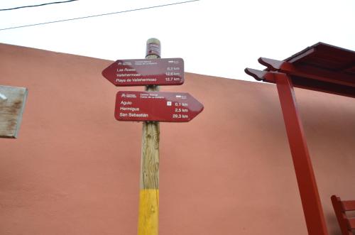 a pole with street signs on it in front of a building at Calma Suite in Agulo