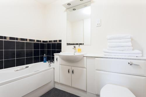 baño blanco con lavabo, bañera y aseo en City View, en Aberdeen