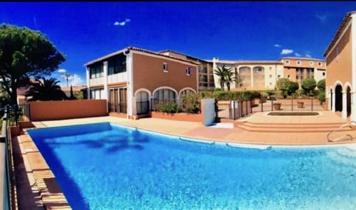 une grande piscine devant un immeuble dans l'établissement Petit Port, à Cogolin