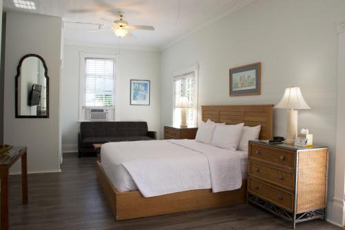 a bedroom with a large bed and a couch at Duval House in Key West