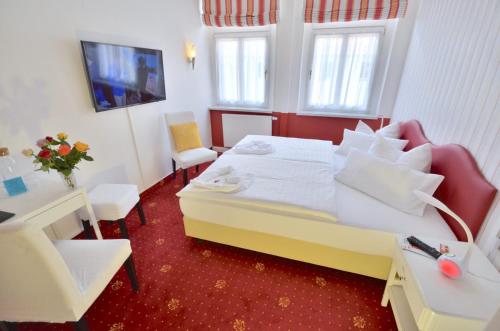 a hotel room with a bed and a table and chairs at Hotel Alt-Connewitz in Leipzig