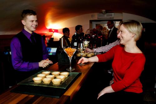 a woman standing at a bar with a tray of cupcakes at Boutique 25 in Skipton