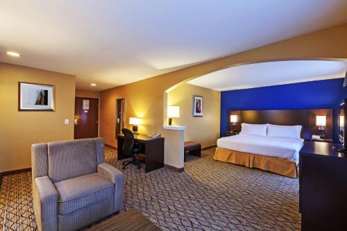a hotel room with a bed and a chair and a desk at Holiday Inn Express Hotel & Suites Houston-Downtown Convention Center by IHG in Houston