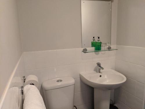 biała łazienka z toaletą i umywalką w obiekcie Aqua Bay Guest House w mieście Herne Bay