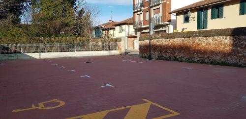 an empty parking lot next to a brick wall at La Corte B&B in Candiolo