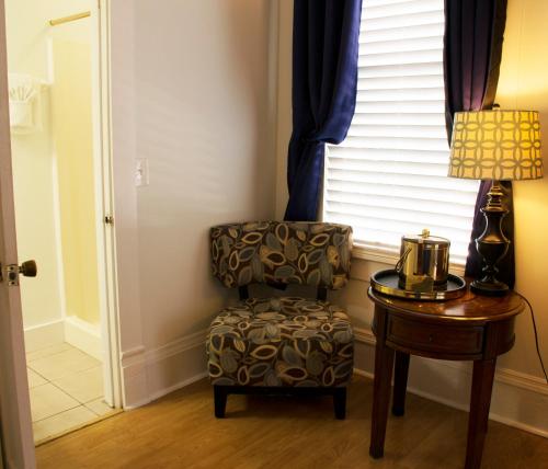 a chair sitting next to a table with a lamp at Duval House in Key West