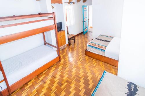 a room with two bunk beds and a wooden floor at Acoma in Otavalo