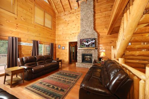 a living room with a couch and a fireplace at Majestic Manor Cabin in Waldens Creek