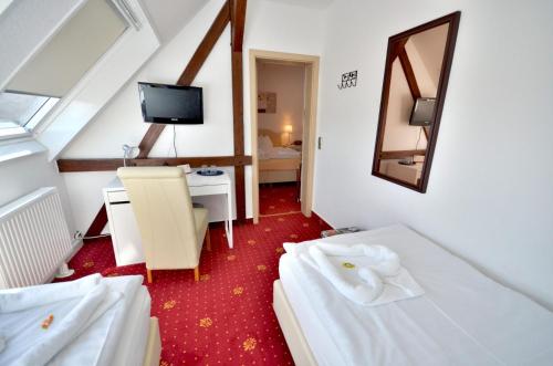 a hotel room with two beds and a television at Alt-Connewitz Hotel in Leipzig in Leipzig