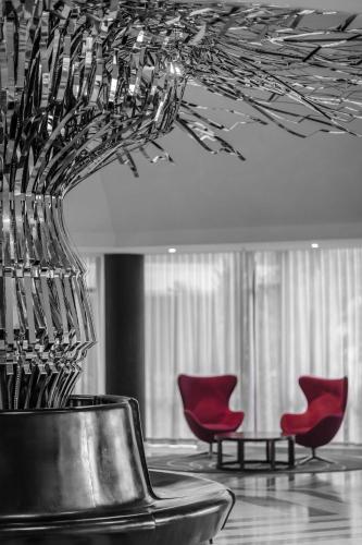 a room with two red chairs and a vase in a room at Radisson Blu Okoume Palace Hotel, Libreville in Libreville
