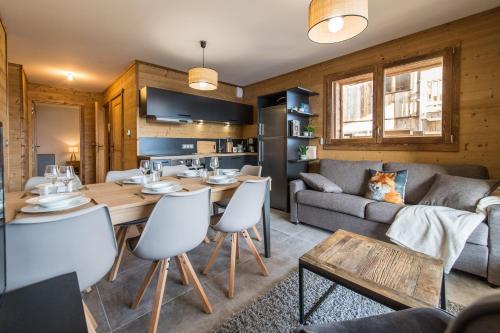 uma sala de estar com uma mesa e um sofá em ODYSSEE CRC01 Appartement traversant sur les pistes em La Toussuire