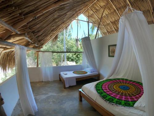 een slaapkamer met een hemelbed en een raam bij Hotel Jasayma dentro del Parque Tayrona in El Zaino