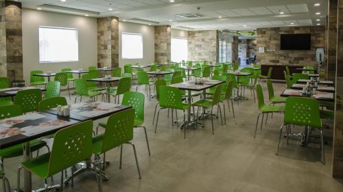 a dining room with tables and green chairs at Holiday Inn Express and Suites Celaya by IHG in Celaya