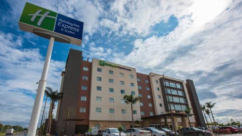 a hotel with a sign in front of a parking lot at Holiday Inn Express and Suites Celaya by IHG in Celaya