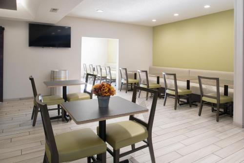 a dining room with tables and chairs and a waiting room at Holiday Inn Express Hotel & Suites Burlington by IHG in Burlington