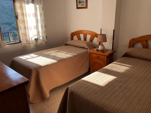 ベナマオマにあるBenamahoma Ruralのベッドルーム1室(ベッド2台、窓、テーブル付)