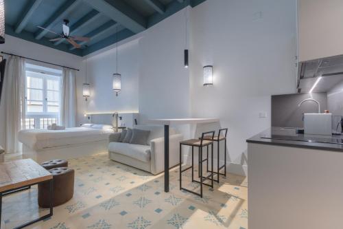 cocina y sala de estar con sofá y mesa en Apartamentos Caminante del Agua, en Sevilla