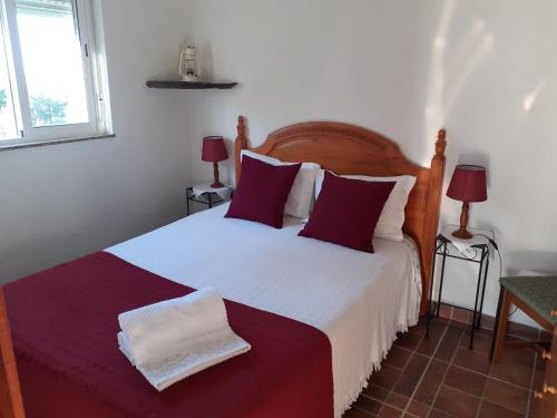 a bedroom with a large bed with red and white sheets at Quinta Das Lameirinhas in Marvão