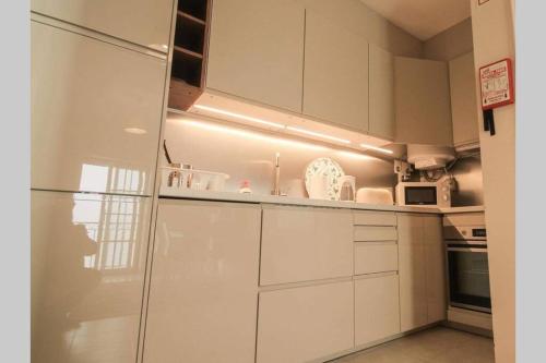 a kitchen with white cabinets and a refrigerator at Townhouse w Beautiful terrace - 360 degrees views! in Lagos